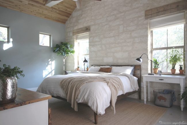 simple, rustic bedroom with stone wall 