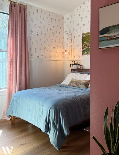 Finished teen bedroom makeover with floral wallpaper, soft pink details, dusty blue bedding and natural wood accents.